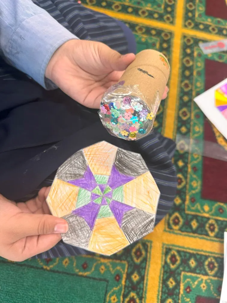 Students holding up the patterned kaleidoscopes they made