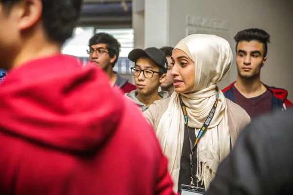 A volunteer tour guide leading a group of students